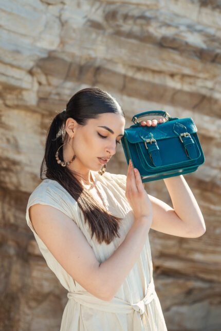 Woman holding a small leather mini satchel bag for women by Jirakis Leather.