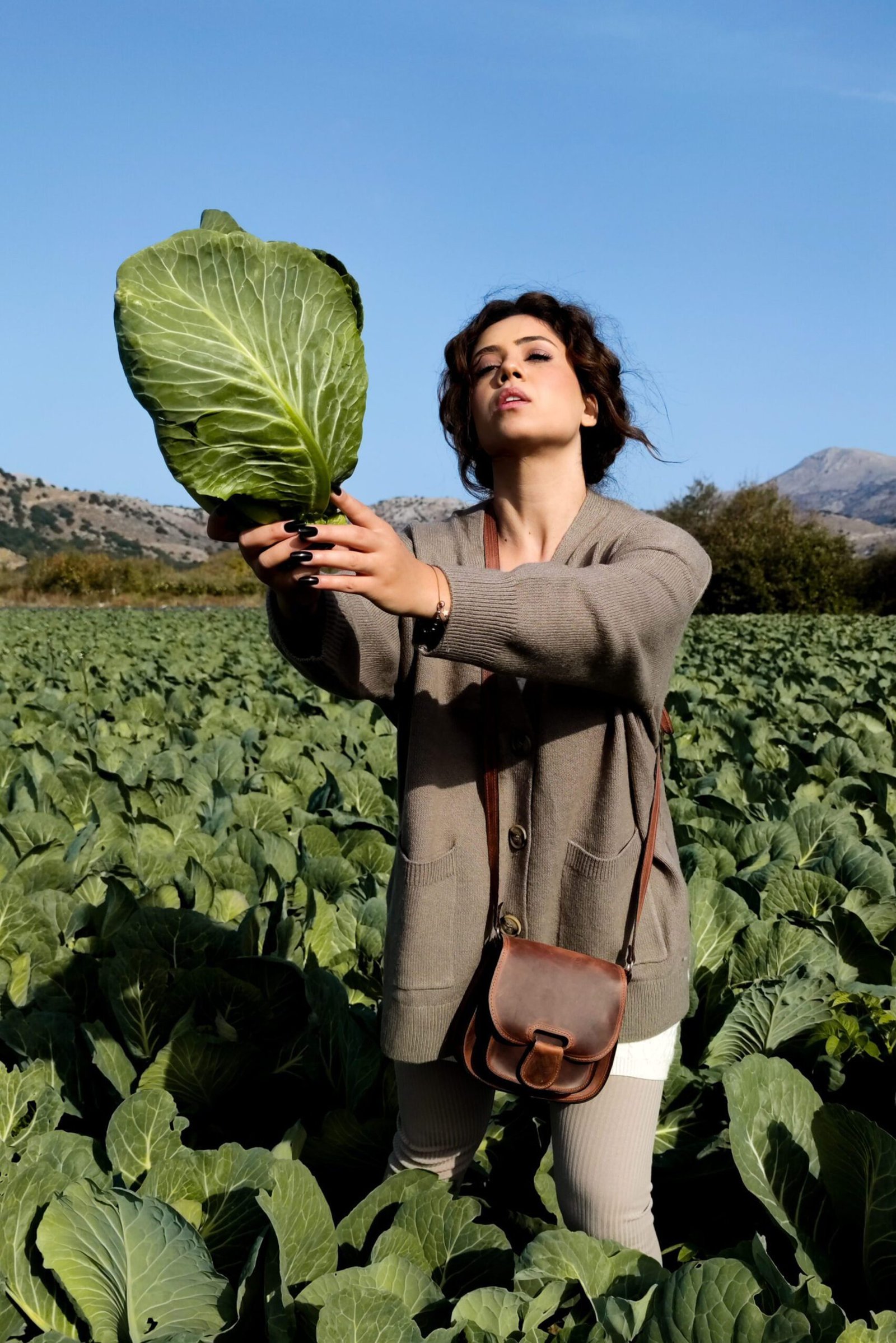 leather-shoulder-crossbody-bag-brown Model holding a Leather shoulder crossbody bag medium size handcrafted in Crete by Jirakis Handcrafted Leather
