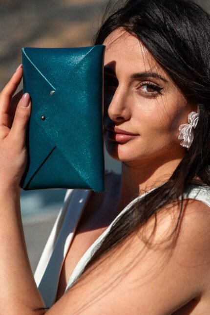 Model holding Handmade leather envelope clutch handcrafted in Crete