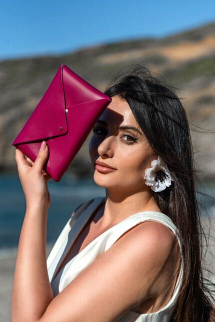 Model holding a Leather pouch clutch handcrafted in Crete by Jirakis Handcrafted Leather